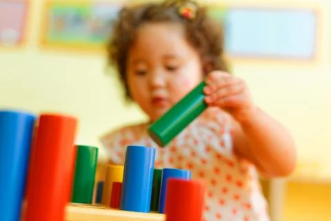 Kazakh curly girl playing in kids development center Stock Photos