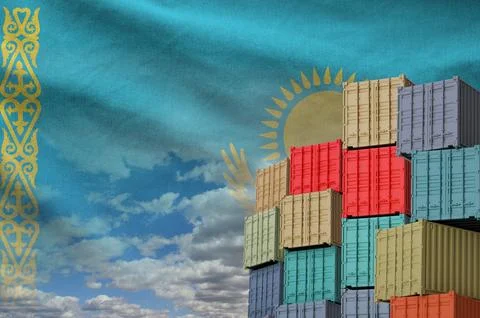 Kazakhstan flag and big stack of shipping cargo containers in docks with sky Stock Photos