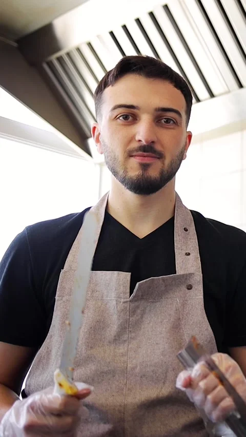 Kebab maker standing on kitchen in street food restaurant. Chef making a kebab Stock Footage 277410234