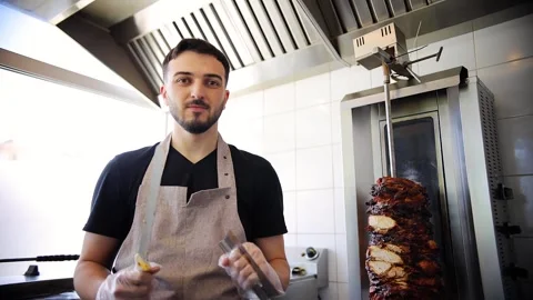 Kebab maker standing on kitchen in street food restaurant. Chef making a kebab Stock Footage 277410239