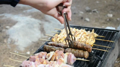 Kebabs being turned on a grill Stock Footage 32927941