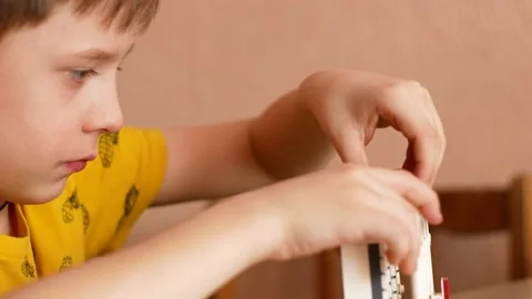 A keen boy 6-7 years old plays a constructor builds a tower building. The child Video stock 167944707