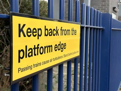 Keep back from platform edge yellow sign at railway station Stock Photos