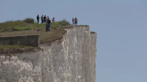 Keep back! Sun-seekers dice with death to take selfies on cliff edges on Stock Footage 273016532
