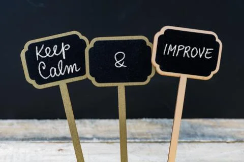 Keep Calm and Improve message written with chalk on mini blackboard labels Stock Photos