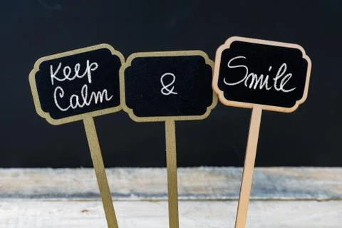 Keep Calm and Smile message written with chalk on mini blackboard labels Stock Photos