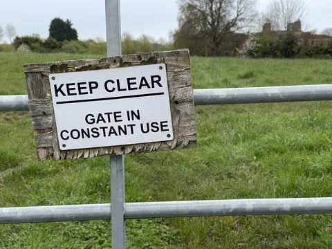 Keep clear gate in use sign on a metal fence gate Stock Photos