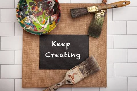 Keep creating sign for creative artist paint brushes flat lay Stock Photos