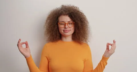 Keep emotions under control. Relaxed curly haired European woman closes eyes Stock Footage 151627071