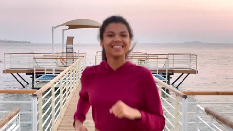 Keep going. Close up of smiling young woman jogging along the beach on the Stock Footage 151608477