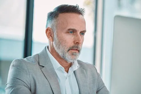 Keep on going. a mature man using a computer at work in a office. Foto stock