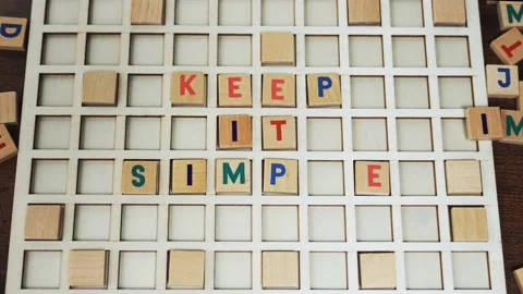 Keep it simple. Good advice concept. Colourful wooden square letters creating Stock Footage 202228053