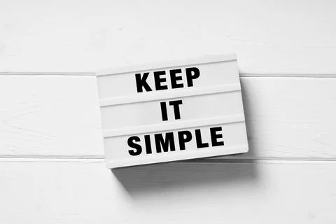 Keep it simple text on lightbox sign, minimal flat lay design on white wooden Foto stock