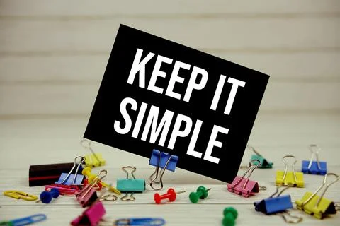 Keep It Simple text on paper card with stationary on wooden background Stock Photos