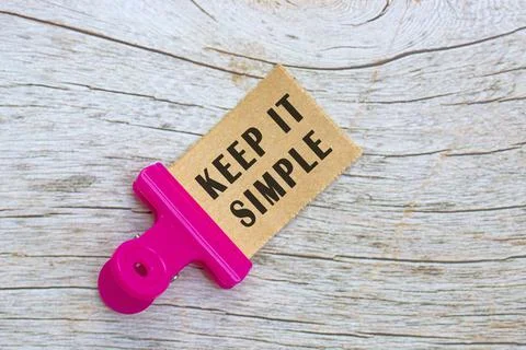 Keep it simple town brown paper with paper clip on wooden table background. Stock Photos