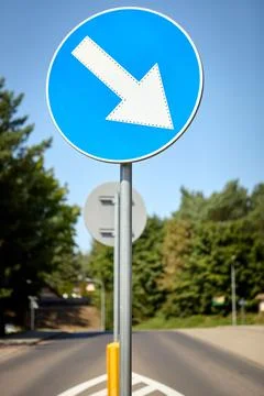 Keep left blue circular road sign on roadside with trees in background Foto stock