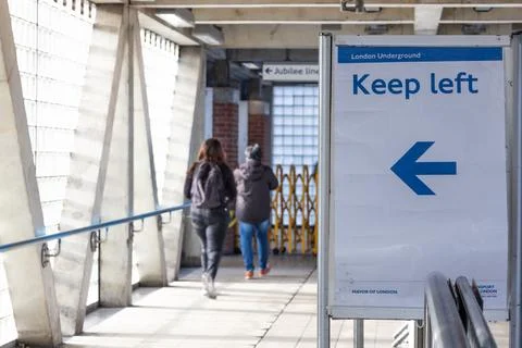 Keep Left Sign with Blue Arrow Directing Pedestrians in Urban Walkway Stock Photos