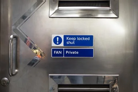 Keep locked shut and private signs on industrial stainless steel door Stockfoto's