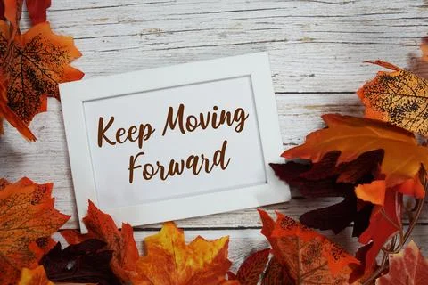 Keep Moving Forward text with maple leaf decoration on wooden background Stock Photos