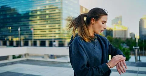 Keep pushing until you see progress. a young woman looking at her watch while Stock Photos