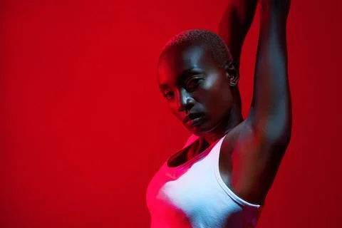 Keep pushing your limits. Red filtered shot of a sporty young posing in the Stock Photos