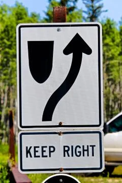 A keep right information sign with trees in the background Stock Photos