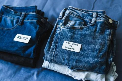 Keep vs Declutter &amp; donate label on different jeans in various denim colors,  Stock Photos