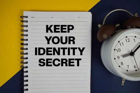 Keep Your Identity Secret text written on notepad with alarm clock on yello.. 库存照片