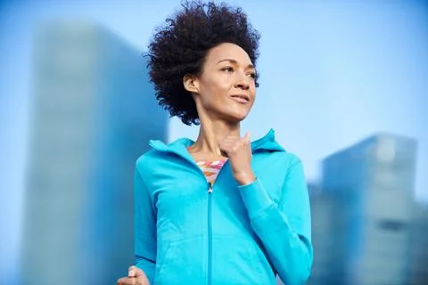 Keeping her own pace. a young woman jogging through the city. Stock Photos