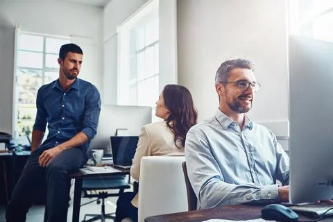 Keeping his commitment he made to his teams goal. mature businessman using a Stock Photos