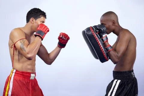 Keeping their reflexes sharp. Two young fighter practicing together in a gym. Stock Photos