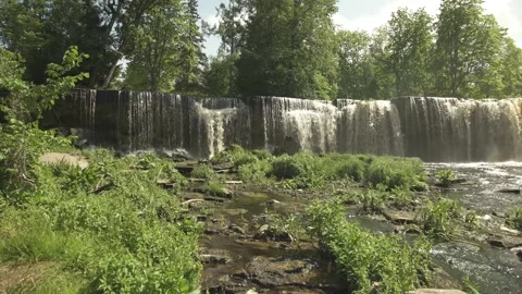 Keila waterfall with stream and grass in foreground in summer day Stock Footage 159980933