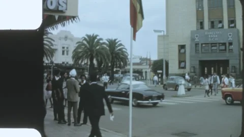 Kenya 1970s, View of a large building beside street with vintage car movement in Stock Footage 313782795