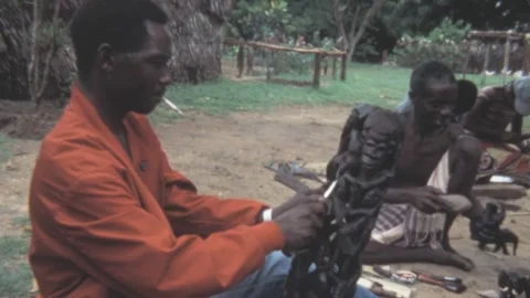 Kenya - 1981: Wood carvers create traditional ebony sculptures in a village Stock Footage 307476716