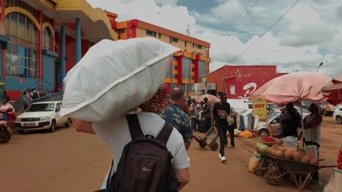 Kenya, Kitale - May 3, 2025: Two caucasian men carry large polypropylene sacks Video stock 313038430