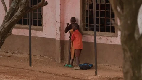 Kenya, Loima - May 5, 2025: Two african boys stand outside school building and Video stock 312568630