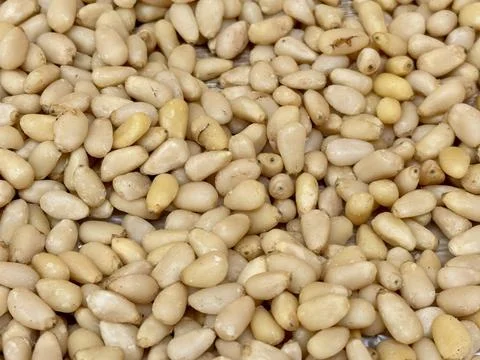 The kernels of peeled pine nuts in a transparent plastic bag for sale by weight Foto stock