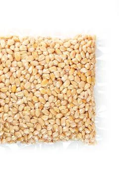 Kernels of peeled pine nuts in vacuum packaging on a white background Foto stock