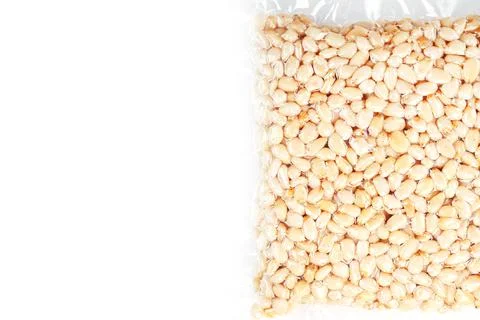 Kernels of peeled pine nuts in vacuum packaging on a white background Foto stock