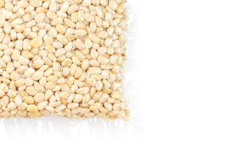 Kernels of peeled pine nuts in vacuum packaging on a white background Foto stock