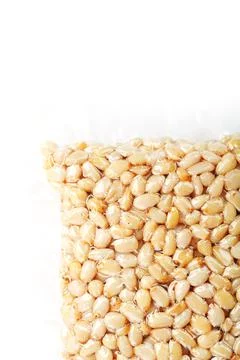 Kernels of peeled pine nuts in vacuum packaging on a white background Foto stock