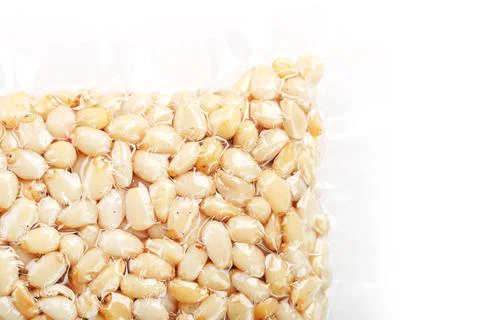 Kernels of peeled pine nuts in vacuum packaging on a white background Foto stock