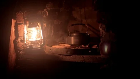 Kerosene lantern picked up in front of a small fire Stock Footage 102383014