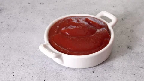 Ketchup in a bowl close-up on the kitchen table Vidéo 223375486
