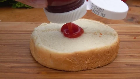 Ketchup squeeze on toast bun Stock Footage 71283393