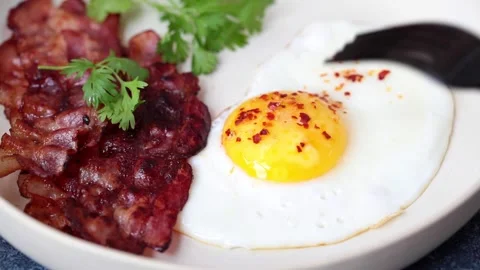 Keto breakfast - fried egg, avocado and fried bacon in white plate. Keto diet Stock Footage 130939183