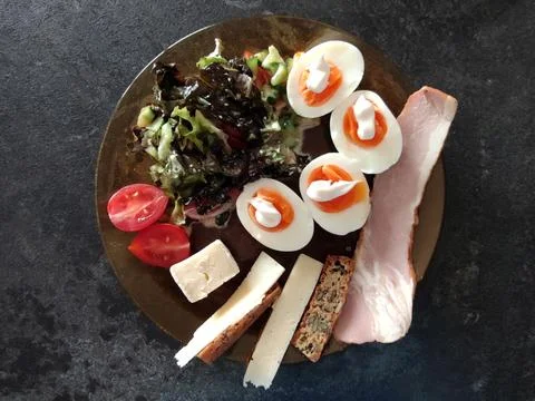 Keto breakfast. A slice of bacon with a vegetable salad, boiled eggs with may Stock Photos