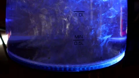 Kettle With A blue Light Boiling Water In A dark Room Video stock 138109276