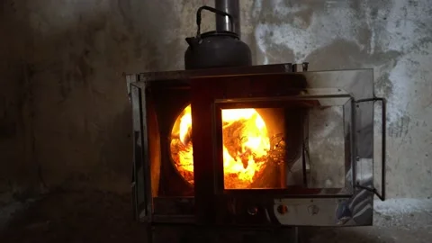 A kettle is boiling on a camp stove with fire. Video stock 232720393