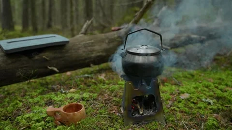 Kettle is boiling on a foldable camping stove 스톡 동영상 295447387